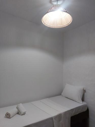 a white room with a table and a light at Pousada Rocas Beach in Pôrto de Pedras