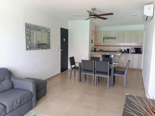 a living room with a couch and a table with chairs at Beautiful condo in Cancun! Dreams Lagoon in Cancún