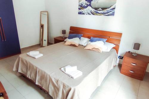 una camera da letto con un grande letto con due asciugamani di Blue Wave Holiday House ad Aci Castello