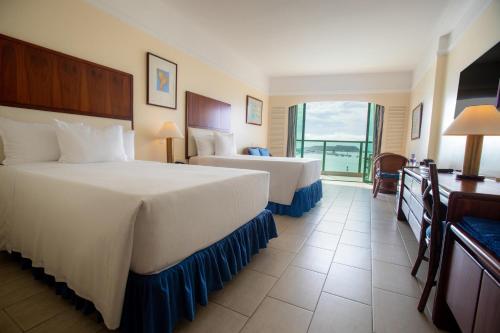 a hotel room with two beds and a balcony at Hotel Colon Salinas in Salinas