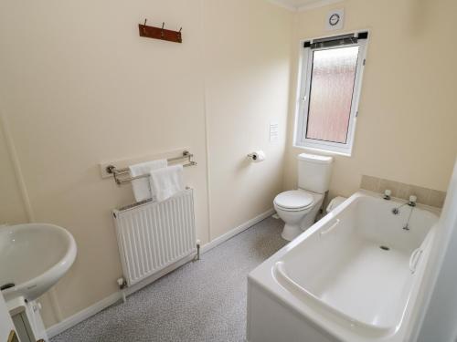 uma casa de banho com uma banheira, um WC e um lavatório. em Snowdrop em Leominster