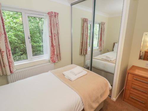 een slaapkamer met een bed en een spiegel bij Daffodil in Leominster