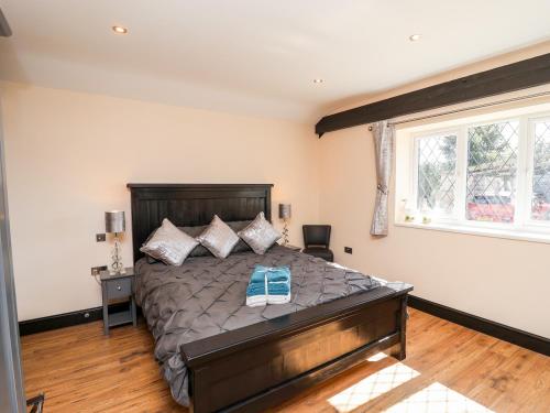 a bedroom with a large bed and a window at Moor Farm Cottage in Chesterfield
