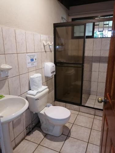 a bathroom with a toilet and a sink at Hotel Cibeles Resort in Heredia