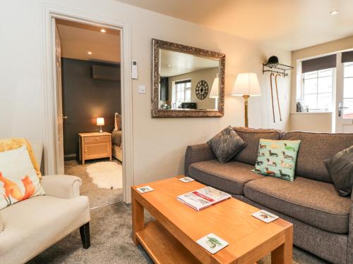 uma sala de estar com um sofá e uma mesa em Well Cottage em Malmesbury