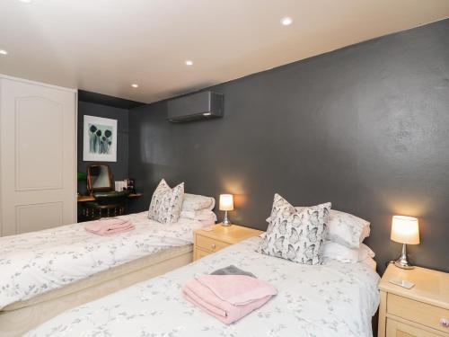 two beds sitting next to each other in a bedroom at Well Cottage in Malmesbury