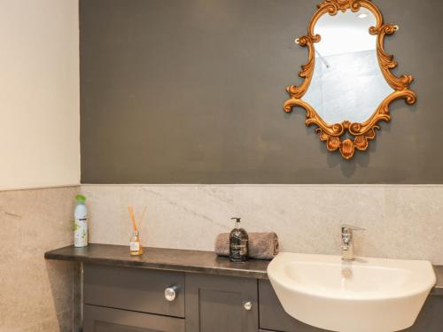 a bathroom with a sink and a mirror on the wall at Well Cottage in Malmesbury