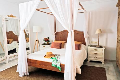 a bedroom with a canopy bed with white drapes at Villa Paula Valencia in Manises
