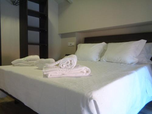 a white bed with towels on top of it at Rua Grande Hotel in Viana do Castelo
