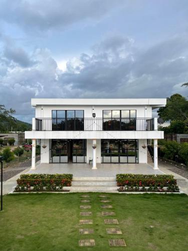 Casa blanca con balcón y patio en Casa Del Río en Montería