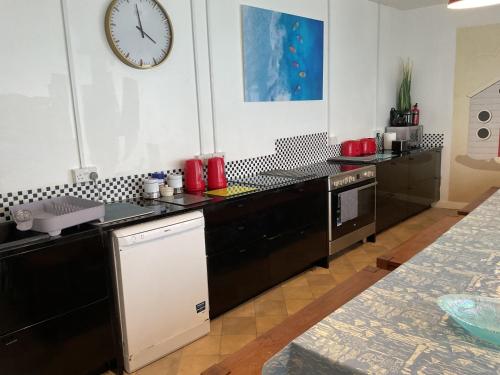 a kitchen with black cabinets and a clock on the wall at Admiralty House in Weymouth