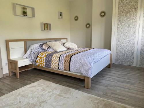 a bedroom with a bed with a wooden frame at LA MAISON DES ARUMS-WIFi-JARDIN PRIVE-PROPERTY RENTAL NM in Trélissac