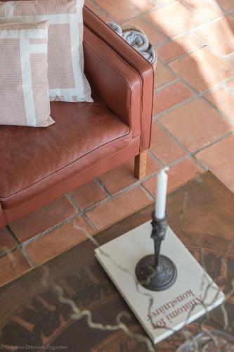 a candle on a plate in front of a couch at Villa Verde Österlen in Glemminge