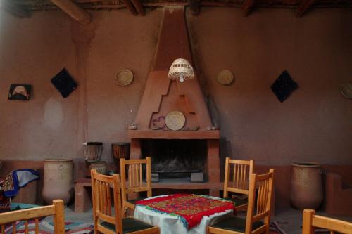 a room with a table and chairs and a fireplace at Maison d'Hôte La Roche Noire in Fint