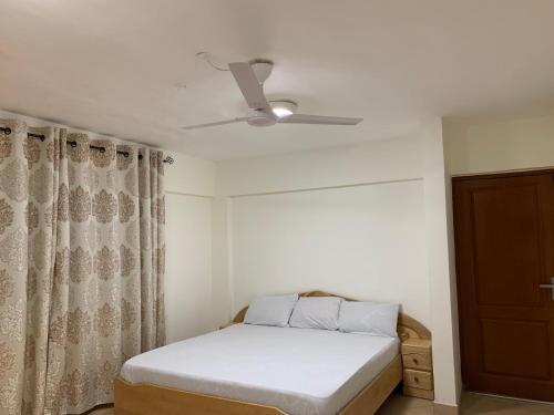 1 dormitorio con 1 cama y ventilador de techo en One Bedroom Cozy Apartment- KNUST & free Parking, en Kumasi