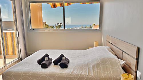 a bedroom with a bed with two pairs of shoes on it at Le Côte et Mer in Nice