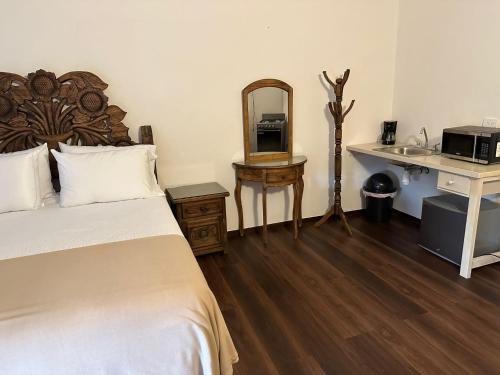 a bedroom with a bed and a sink and a mirror at Bebelines inn dos in San Miguel de Allende