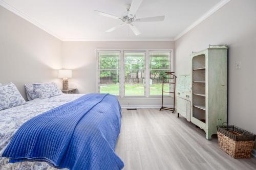 um quarto com uma cama e uma ventoinha de tecto em The Cozy Cottage - 10 Min From UNC em Chapel Hill