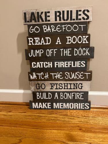 a stack of wood signs on a wall at Modern 3br Lake front home in Sanford