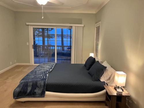 a bedroom with a bed and a large window at Modern 3br Lake front home in Sanford