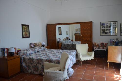 a bedroom with two beds and two white chairs at Antico Casale Pizzo in Palazzolo Acreide