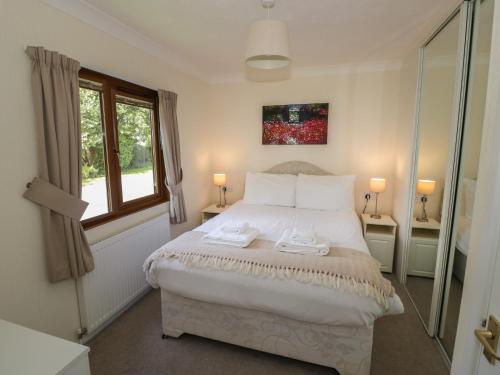 een slaapkamer met een groot wit bed en een raam bij Bluebell in Leominster
