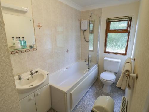 een badkamer met een toilet, een bad en een wastafel bij Bluebell in Leominster