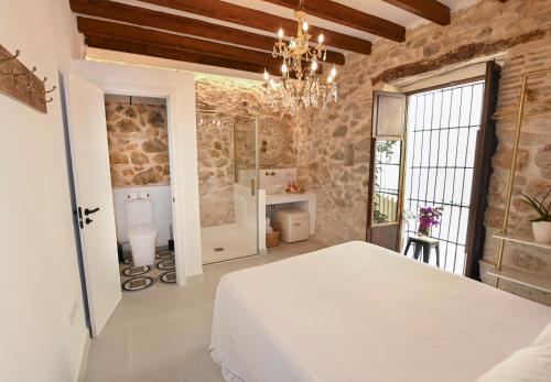 a bedroom with a white bed and a stone wall at Ca Sana Teulada Moraira, Grupo Terra de Mar, alojamientos con encanto in Moraira