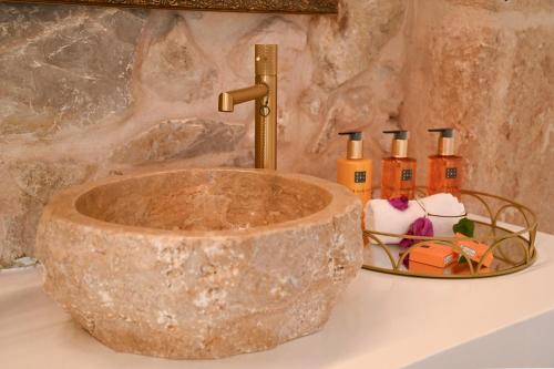 a bathroom with a stone sink and a faucet at Ca Sana Teulada Moraira, Grupo Terra de Mar, alojamientos con encanto in Moraira