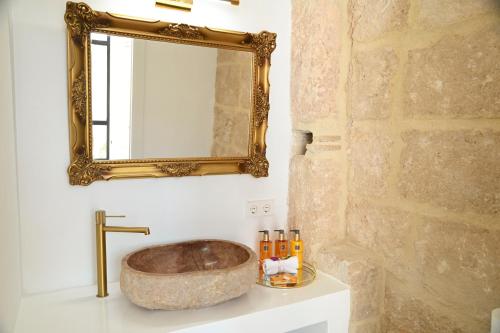 a bathroom with a stone sink and a mirror at Ca Sana Teulada Moraira, Grupo Terra de Mar, alojamientos con encanto in Moraira