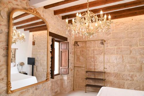 a bathroom with a mirror and a chandelier at Ca Sana Teulada Moraira, Grupo Terra de Mar, alojamientos con encanto in Moraira
