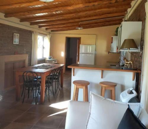 uma cozinha com uma mesa e bancos num quarto em La Adelfa em Esquel