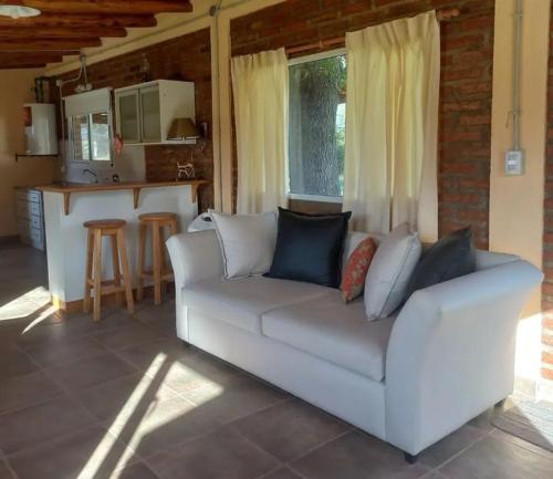 a living room with a white couch and a kitchen at La Adelfa in Esquel