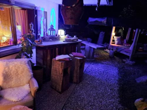 a living room with a table and a chair and lights at Chalet Chnorz Hosted in Nesslau