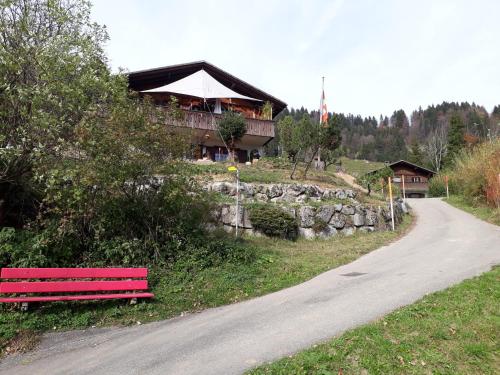 a red bench sitting on the side of a road at Chalet Chnorz Hosted in Nesslau