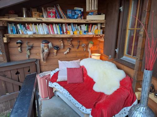 a bedroom with a bed with a red and white blanket at Chalet Chnorz Hosted in Nesslau