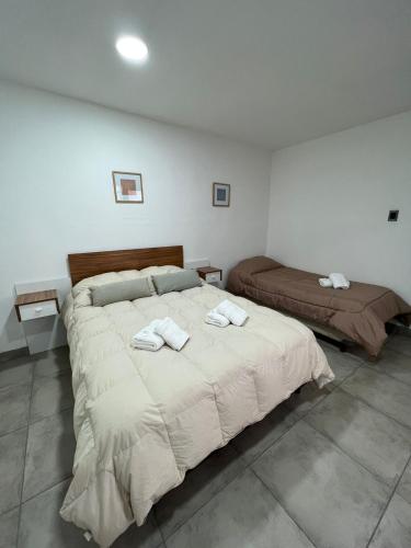 1 dormitorio con 1 cama grande y toallas. en Departamento Plaza en San Martín