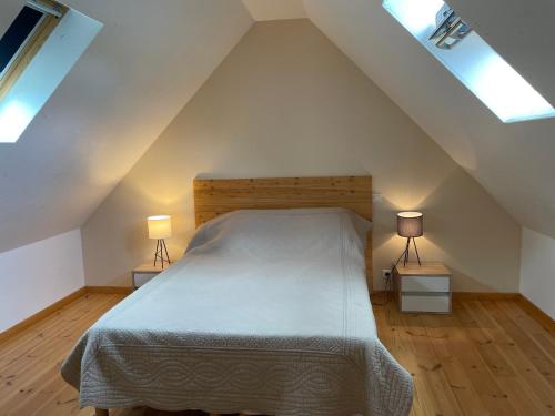 une chambre avec un grand lit avec deux lampes dans l'établissement Gîte dans la Vallée du Lot, à Canilhac