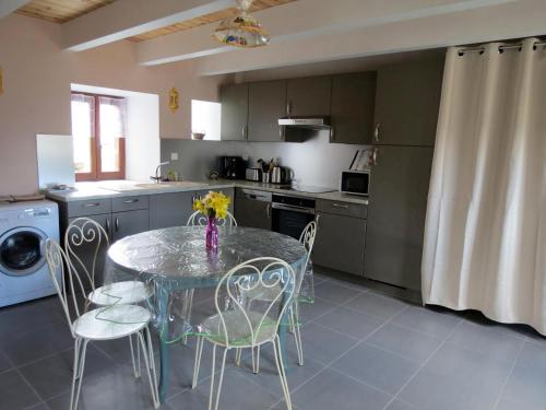 une cuisine avec une table et des chaises dans une cuisine dans l'établissement Gîte dans la Vallée du Lot, à Canilhac