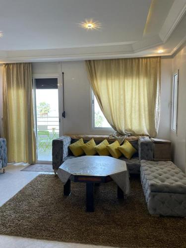 een woonkamer met een bank en een salontafel bij كوثر in Kenitra