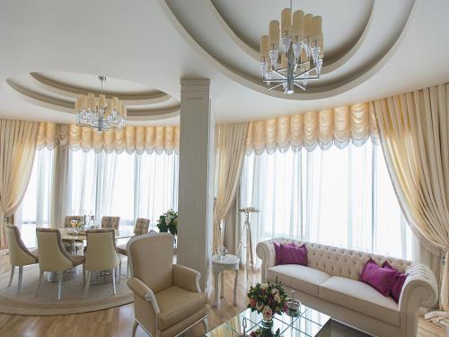 a living room with a couch and a dining room at Qafqaz Sahil Hotel Baku in Baku