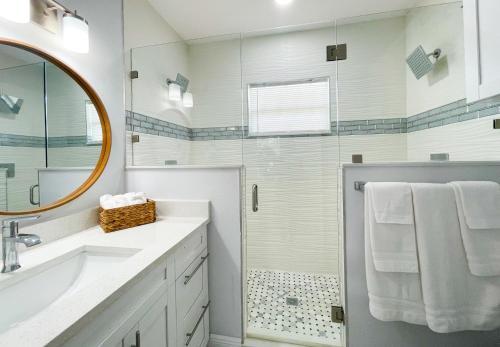 a bathroom with a shower and a sink and a mirror at Cozy Stylish Chic Home Ybor, Dt Central Location in Tampa