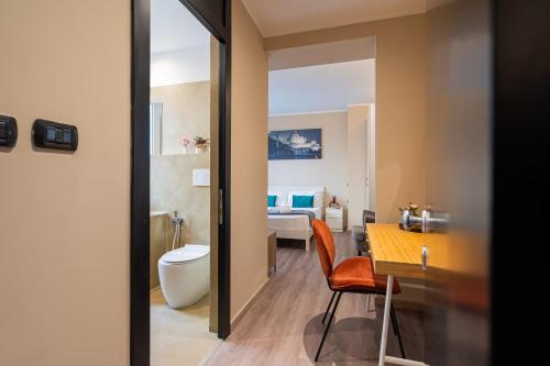 a bathroom with a toilet and a room with a bed at Musa Rooms Roma in Rome