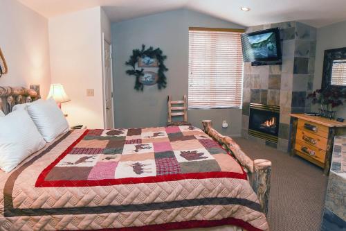 sypialnia z łóżkiem z kołdrą w obiekcie Fawn Valley Inn- 103 condo w mieście Estes Park