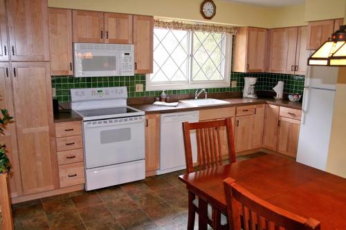 a kitchen with wooden cabinets and a white stove top oven at Fawn Valley Inn- 240 condo in Estes Park