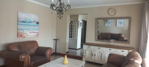 a living room with a couch and a mirror at Entire 4 bedroom house in Midrand, Johannesburg in Randjesfontein