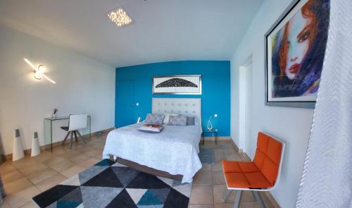 a bedroom with a bed and a orange chair at RESIDENCE VILLA SEA PEARL in Saint Martin