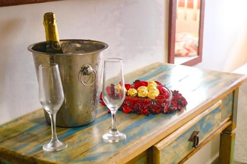a table with two glasses and a bottle of wine at Pousada do Albatroz in Cabo Frio