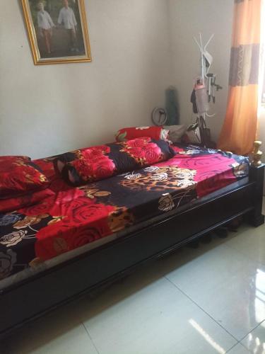 a bed sitting in a living room with avertisement at Regita Homestay Kaledupa in Kaledupa