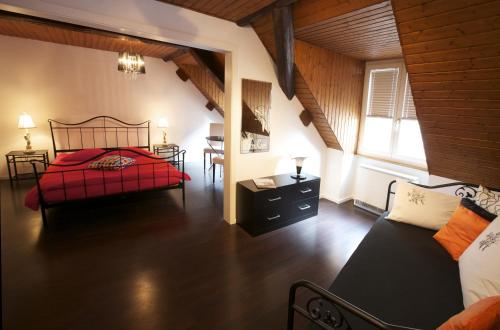 Schlafzimmer mit einem roten Bett und einem Tisch in der Unterkunft Hôtel-Restaurant Le Lion d'Or in Pruntrut